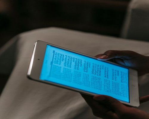 Close-up of a person reading an e-book with a comfortable soft reading light during evening hours