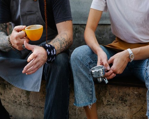 A group of colleagues chatting during a healthy morning coffee break at an outdoor patio in Lima